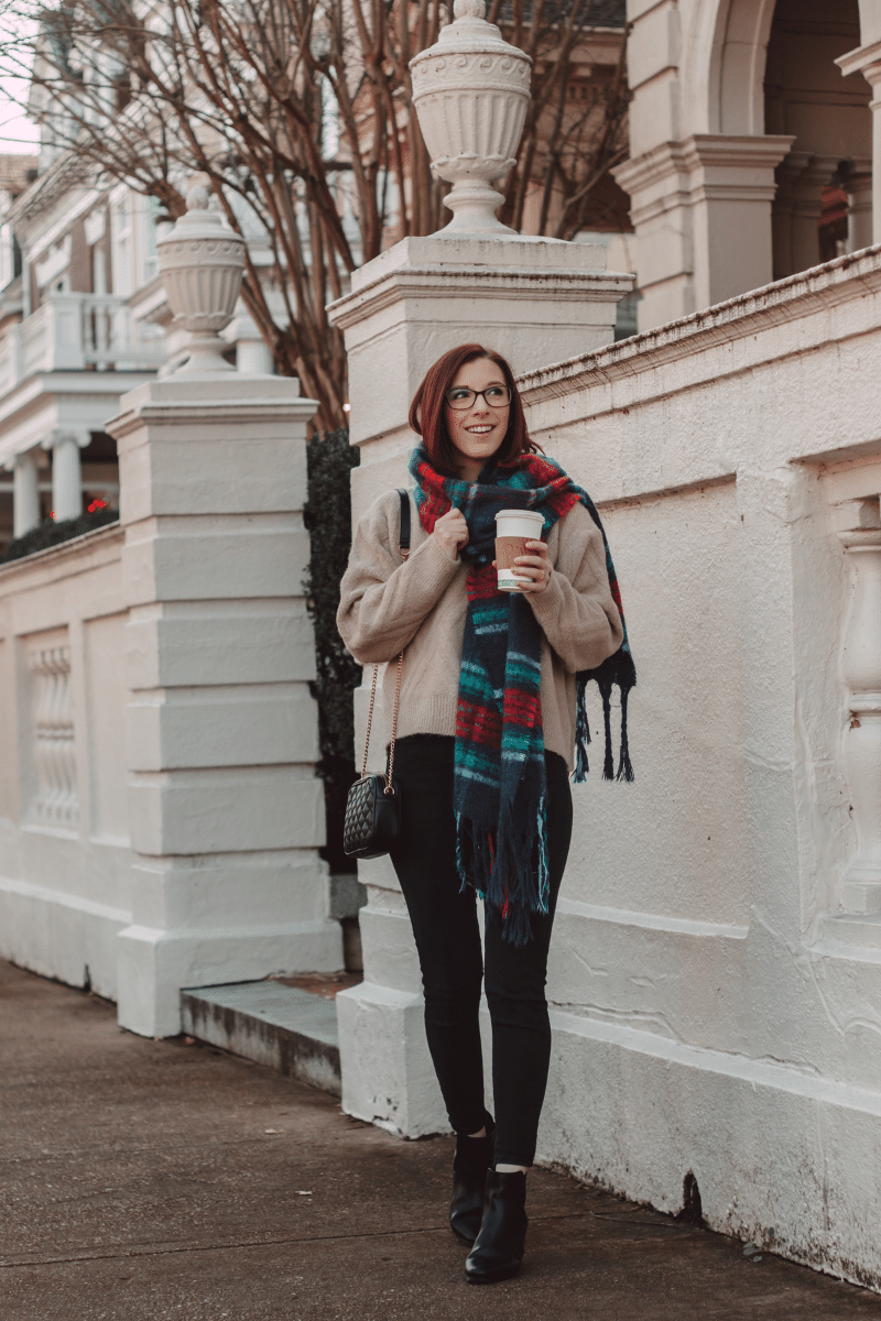 girl holding coffee wearing scarf in casual winter outfit