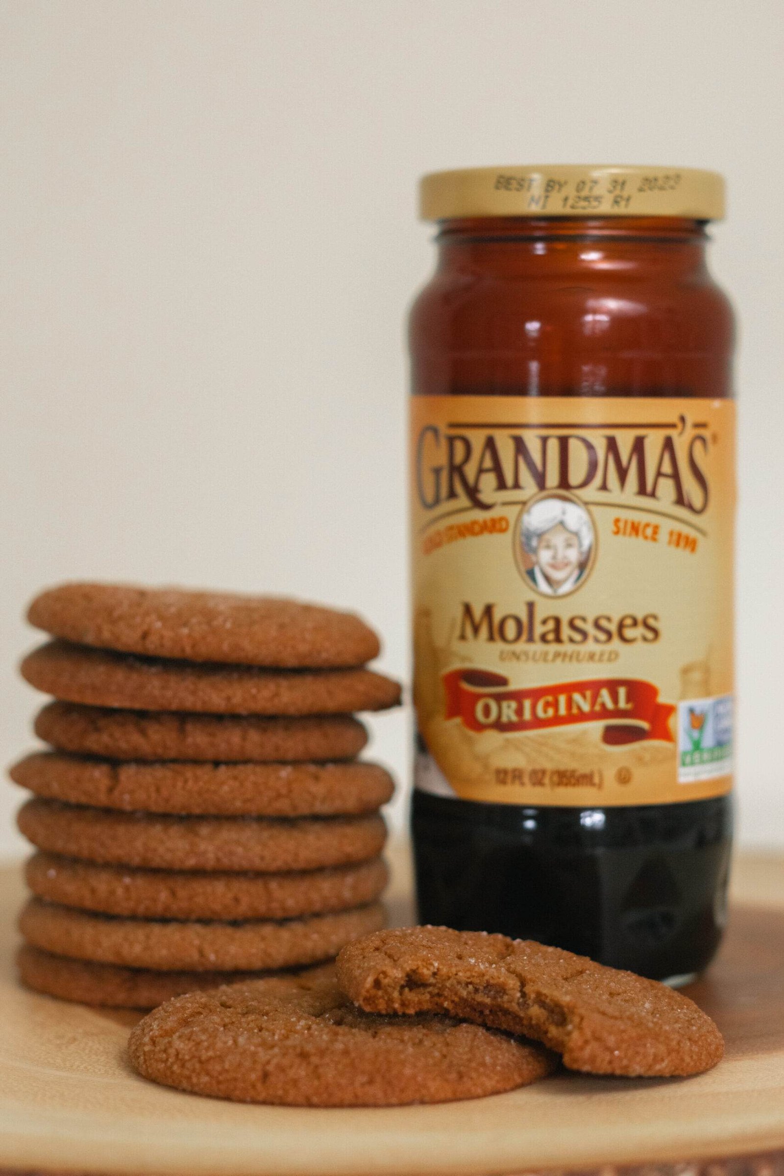 a jar of molasses placed next to a stack of cookies