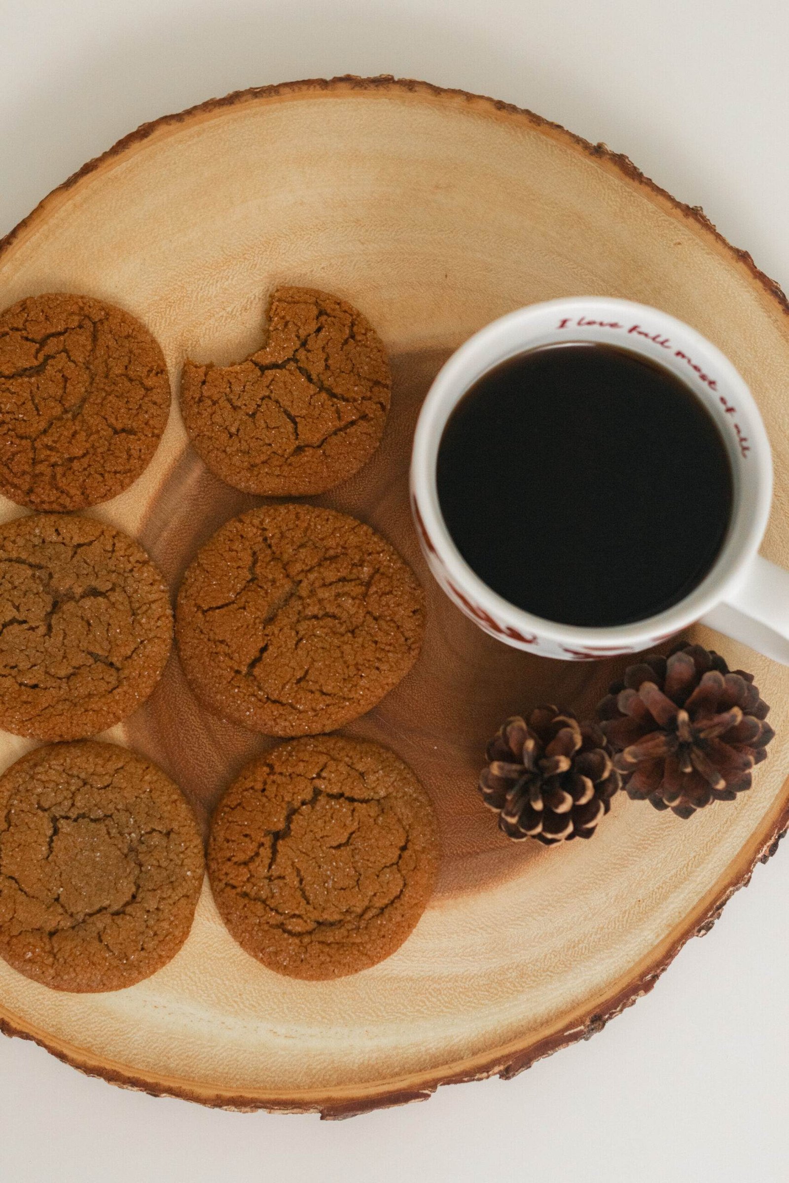 six crinkled molasses cookies next to a mug of black coffee