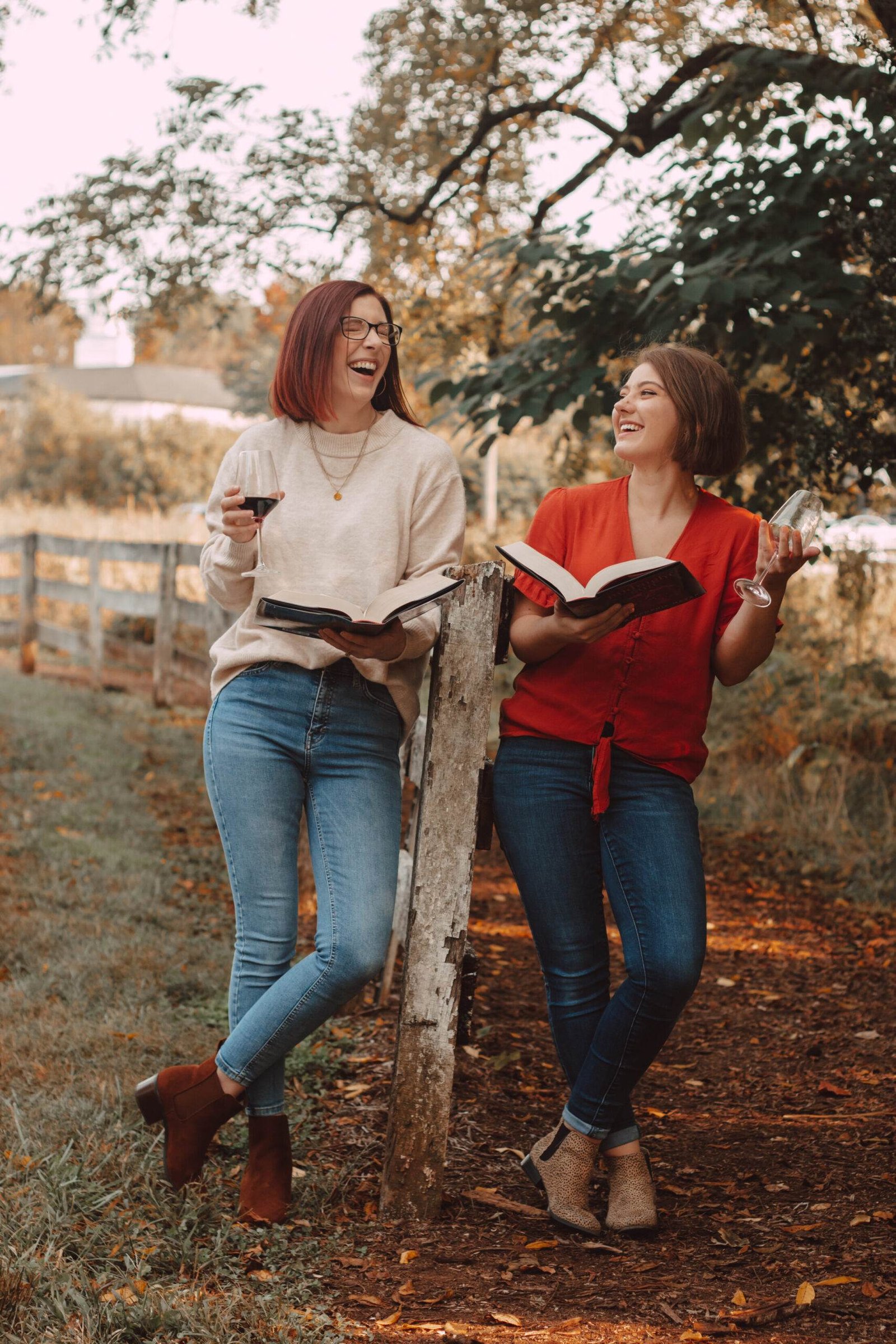 two girls holding midnight sun and laughing by a fence