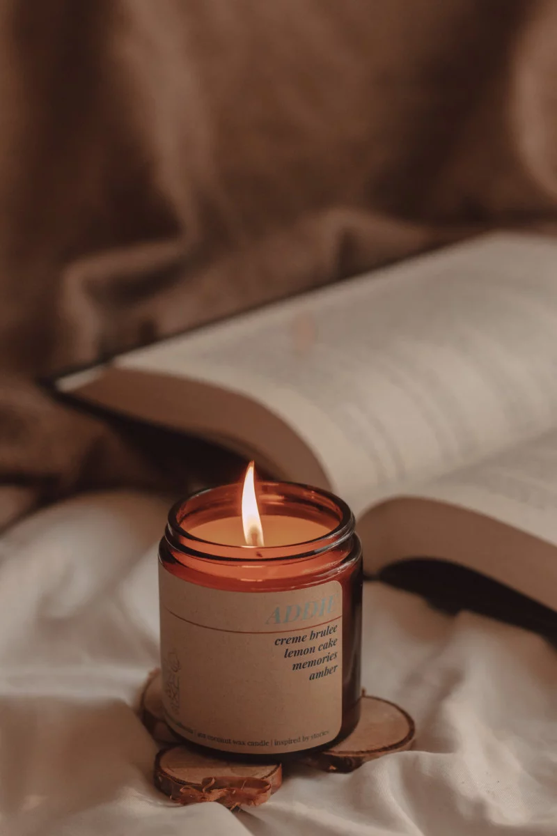 a lit candle named "addie" sits in front of an open book